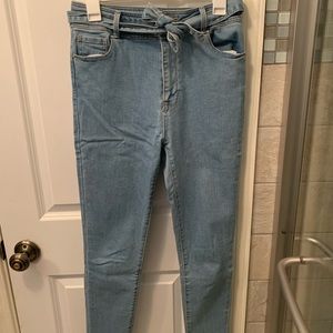 Light wash PACSUN skinny jeans with denim belt.